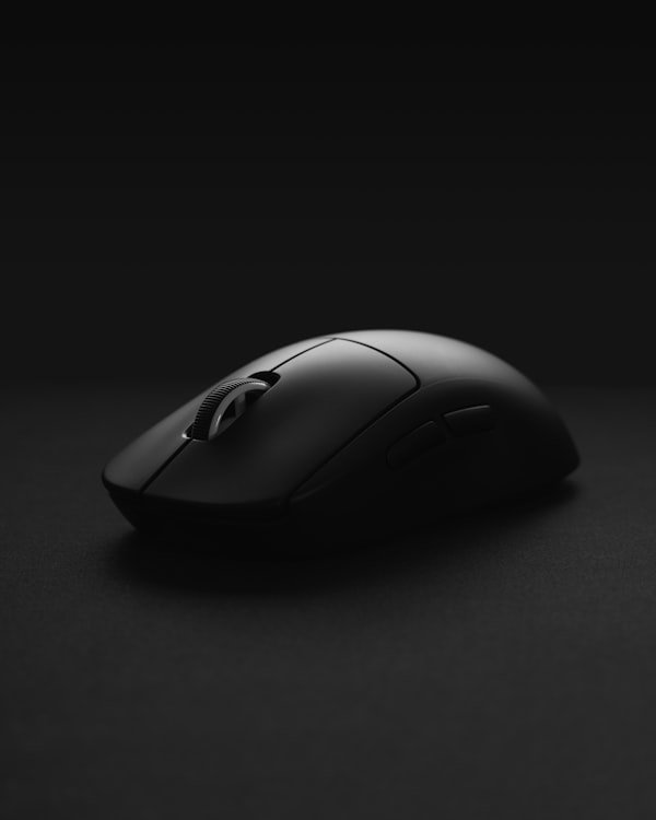 Sleek matte black computer mouse on a dark background.
